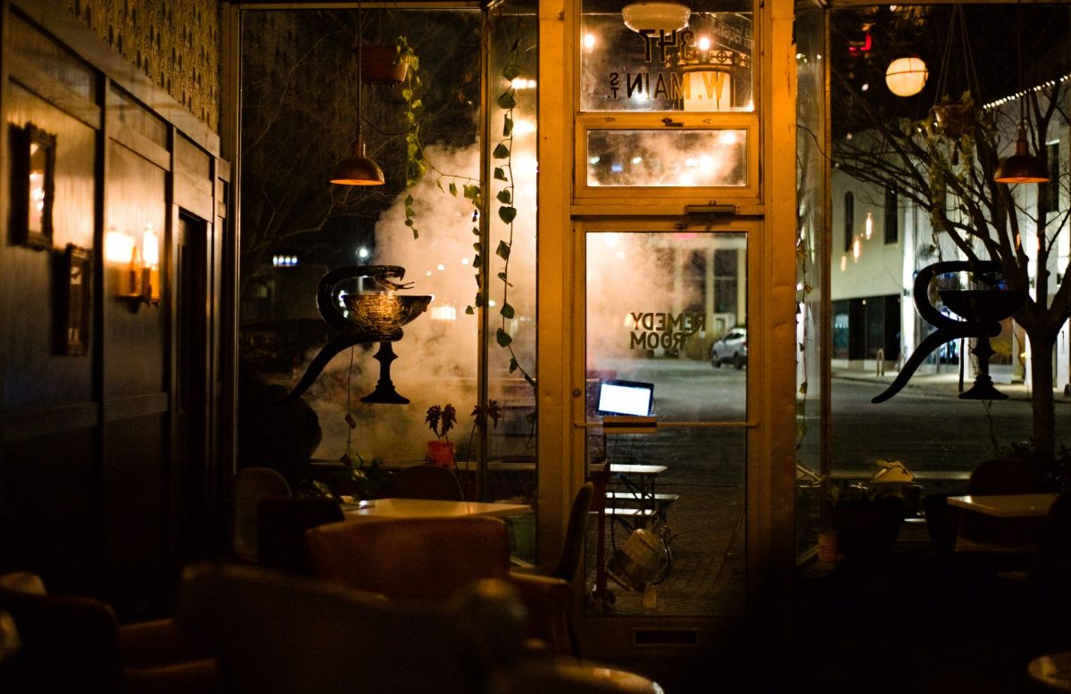 Eclectic empty café filled with vintage objects and warm lights at night.